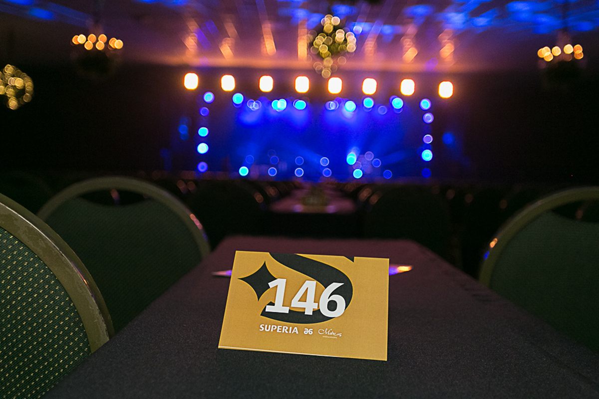 Cartão de mesa numerada Superia A6 com palco ao fundo